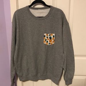 grey crewneck with pineapple printed pocket